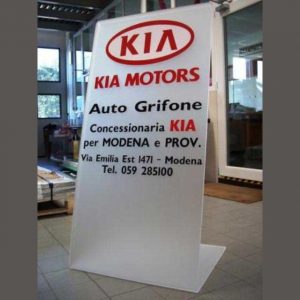 Panneau publicitaire plexiglas autoportant salon auto Kia, en bi-satiné 10 mm. Plié à "L". Autoportant. Lettrage publicitaire en PVC adhésif.