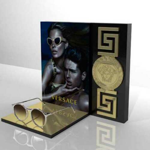 Espositore plexiglass occhiali Versace in oro specchiato per il marchio con marcatura laser, le greche in rilievo e la stampa grigio scuro