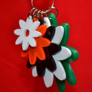 Vue de prés du Porte-clés multifleurs plexiglas de couleur, 5 fleurs de tailles différentes, pour les attacher à des sacs à main ou à des sacs pour filles.