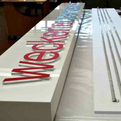Enseigne plexiglas lettres en relief avec caisson opaque, en blanc et lettres en transparent de 15 mm découpées au laser, décorées en rouge